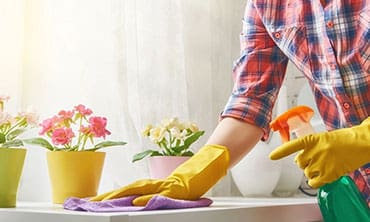 A person in yellow gloves cleaning the counter.