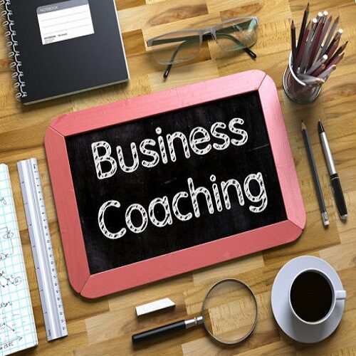 A chalkboard with the words business coaching written on it.